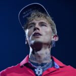 Watch MGK "mess my back up really, really bad" as he somersaults off roof into audience